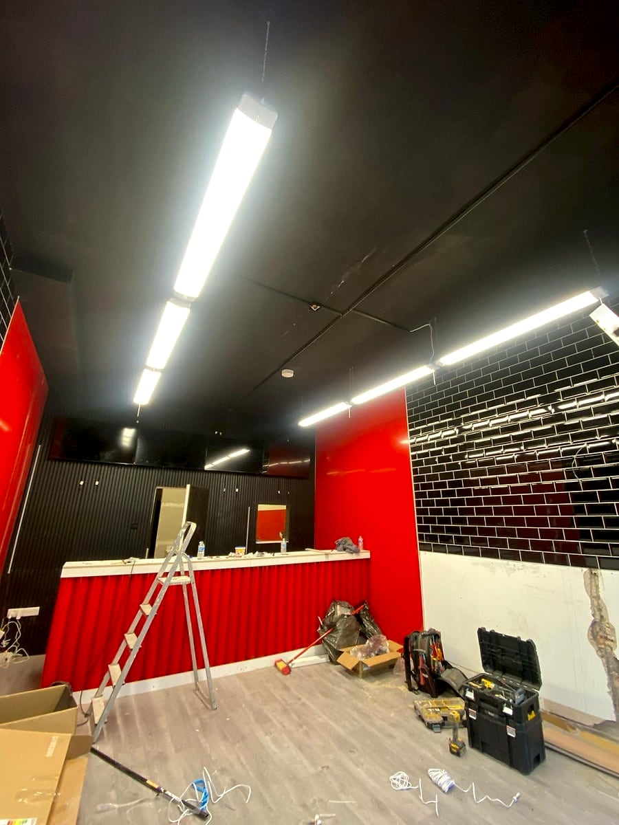 A shop fit-out in progress with new suspended linear LED lights on over the counter