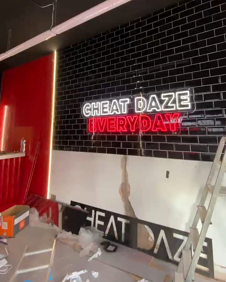 A Cheat Daze dessert bar with the ceiling lights and neon sign on