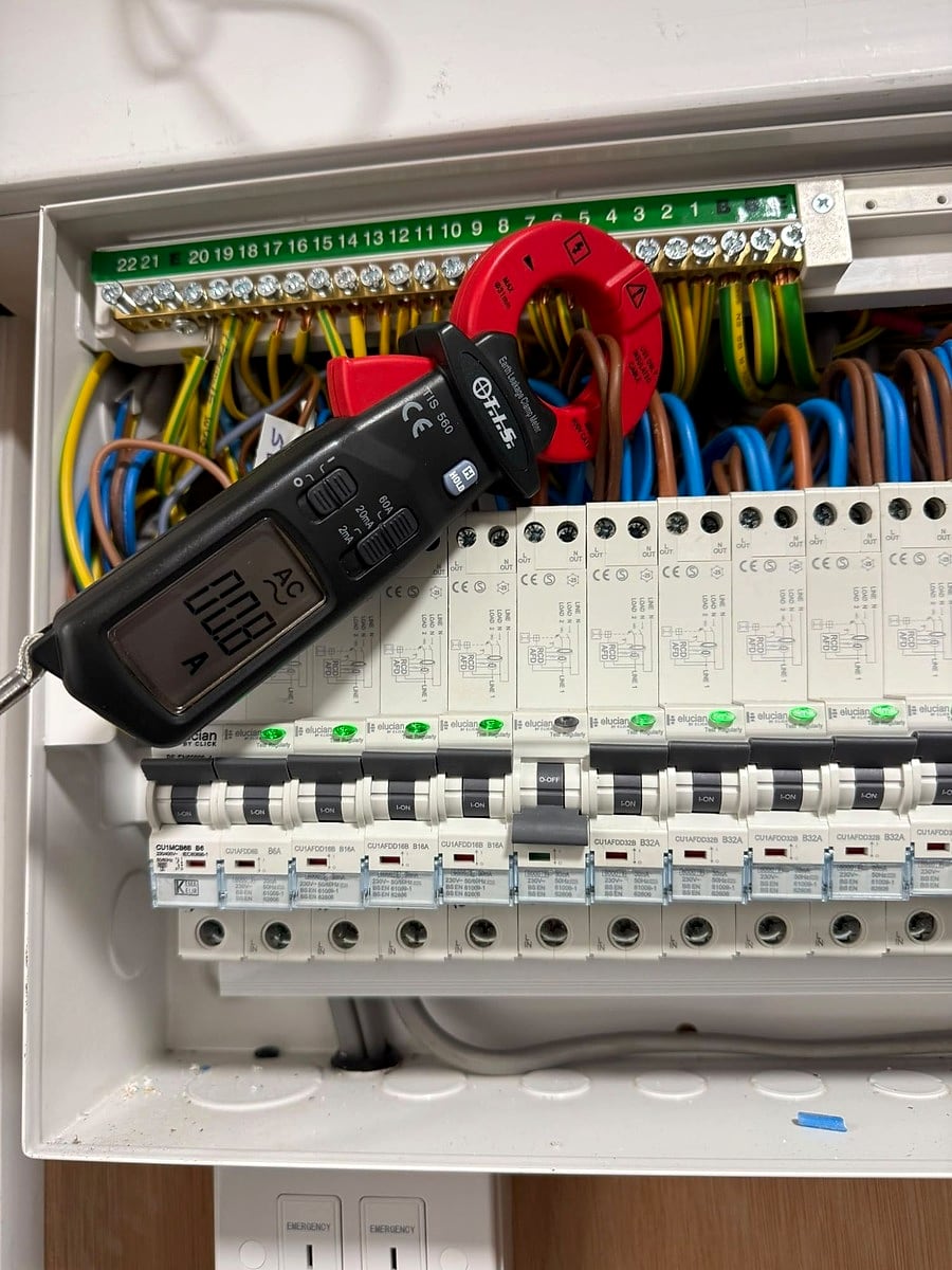 Earth leakage clamp meter round the cables of an RCBO consumer unit during fault finding
